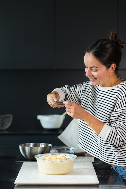 Kobieta robiąca zdjęcie do mediów społecznościowych podczas gotowania ciasta