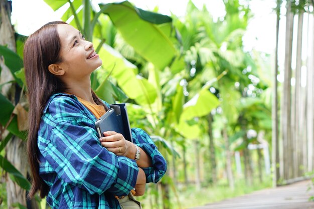 Kobieta rolnik jest zadowolona po obejrzeniu wyników na tle plantacji bananów na laptopie