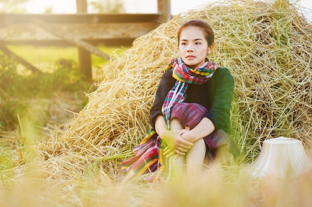 kobieta rolnik odpoczynku ze słomy w polu