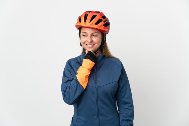 Kobieta rowerzysta średnim wieku samodzielnie patrząc z boku i uśmiechając się