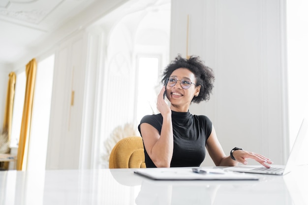 Kobieta rozmawia przez telefon pracując w biurze miejsce pracy coworking laptop na stole finanse w firmie