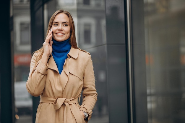 Kobieta rozmawia przez telefon przy banku