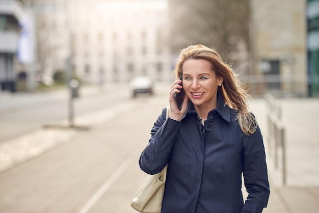 Kobieta rozmawiająca przez telefon na ulicy w mieście