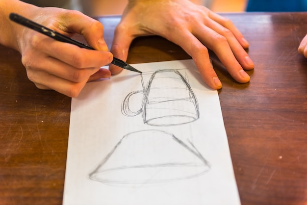 Zdjęcie kobieta rysuje szkic przyszłego glinianego kubka do garncarstwa