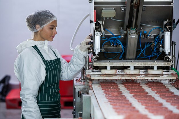 Zdjęcie kobieta rzeźnik przetwarzania hamburger pasztecika