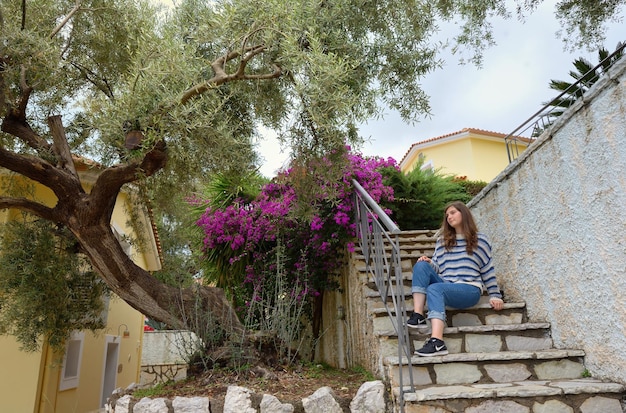 Zdjęcie kobieta siedząca na schodach przy drzewach