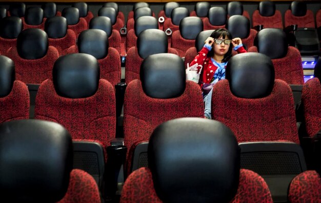 Zdjęcie kobieta siedząca na siedzeniu w teatrze