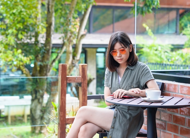 Kobieta siedzi na tarasie kawiarni