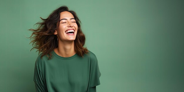 Kobieta śmieje się na izolowanym zielonym tle