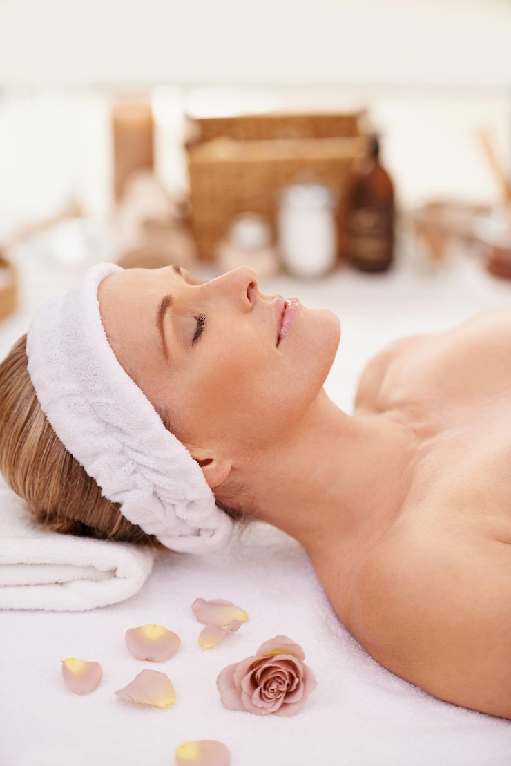 Zdjęcie kobieta spa i odpoczynek dla zen spokoju i dobrego samopoczucia z relaksem i spokojem kobieta ręcznik i stół masażowy w lounge ośrodka lub luksusowy salon z różą dla holistycznego ciała i pielęgnacji skóry dla detoks i przerwy