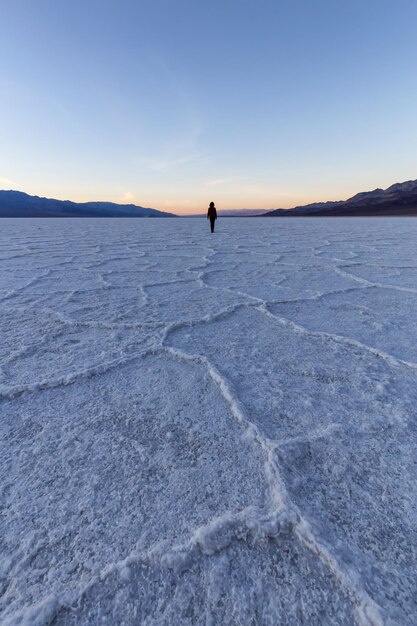 Kobieta spacerująca po Salt Pan w Parku Narodowym Doliny Śmierci w Badwater Basin