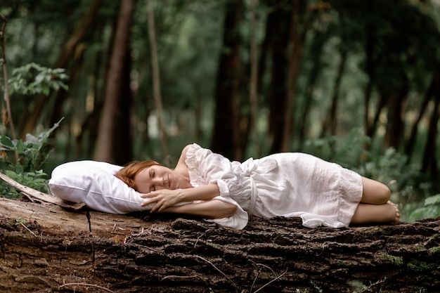 Kobieta śpi w lesie na poduszce
