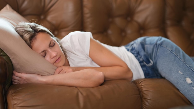 Zdjęcie kobieta śpi w salonie robiąc sobie przerwę na krótką drzemkę w środku dnia