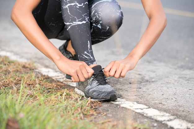 Kobieta sport fitness biegacz przygotowuje się do biegania na zewnątrz na leśnej ścieżce. Buty.