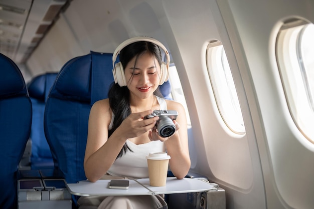 Kobieta sprawdza zdjęcia z aparatu fotograficznego podczas lotu w wakacjach letnich