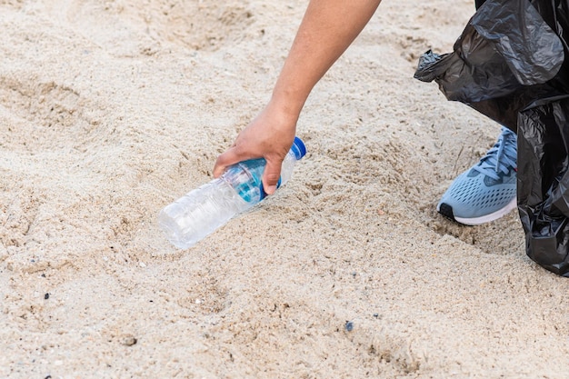 Kobieta sprząta, zbierając plastikowe butelki na plaży Koncepcja ochrony środowiska, oszczędzanie świata, recykling, zmniejszanie globalnego ocieplenia