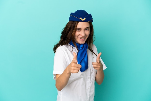Kobieta stewardesa samolotu na białym tle na niebieskim tle skierowana do przodu i uśmiechnięta