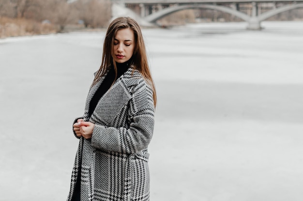 Kobieta stoi nad zamarzniętą rzeką