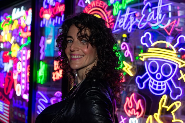 Zdjęcie kobieta stoi przed neonem z napisem „słodki cukierek”