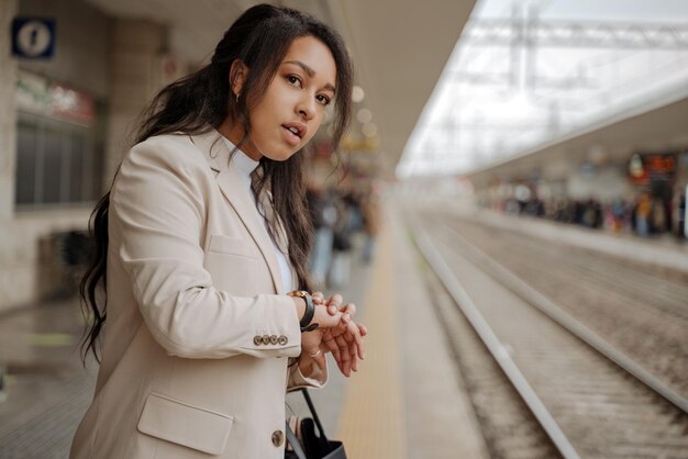 Kobieta stojąc na stacji kolejowej, miejsce. Turysta czekający na pociąg, odwracający wzrok