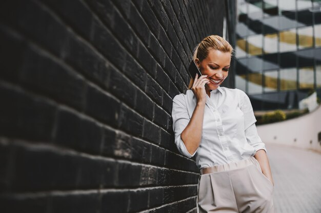 Kobieta stojąc na zewnątrz i za pomocą inteligentnego telefonu