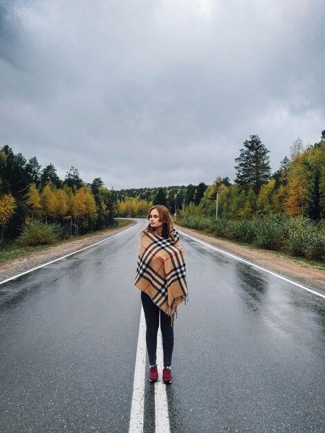 Zdjęcie kobieta stojąca na drodze w deszczu