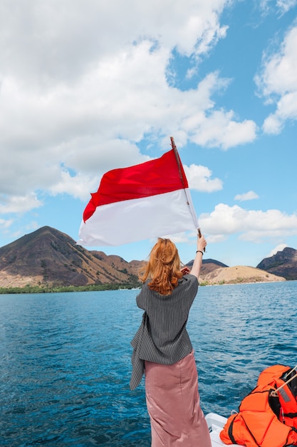 Kobieta Stojąca Na łodzi I Machająca Flagą Indonezji Na środku Morza