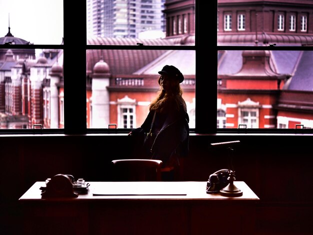 Zdjęcie kobieta stojąca przy oknie w restauracji