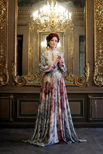 Kobieta stojąca w pałacowej sali z lustrem