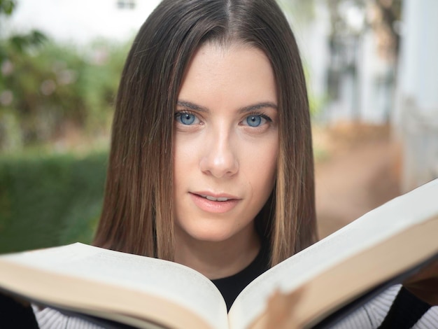 Zdjęcie kobieta stojąca z otwartą książką patrząca na kamerę