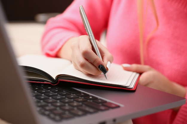 Kobieta studiuje mocno zapisuje informacje do notebooka