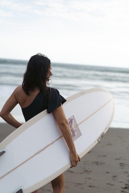 Kobieta Surfer Z Deską Surfingową Na Oceanie O Zachodzie Słońca