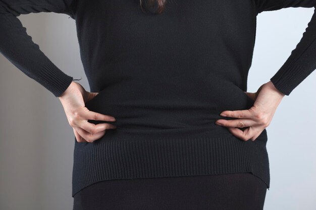 Zdjęcie kobieta szczypie swój gruby brzuch