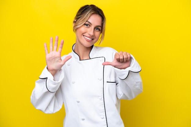 Kobieta szefa kuchni urugwajskiej na żółtym tle, licząc sześć palcami