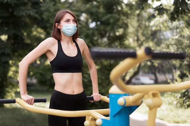 Kobieta szkolenia na następne wydarzenie sportowe podczas noszenia maski medycznej