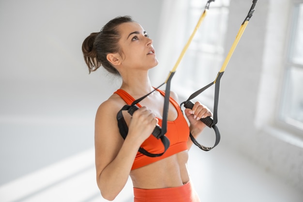 Kobieta trenująca na paskach fitness TRX