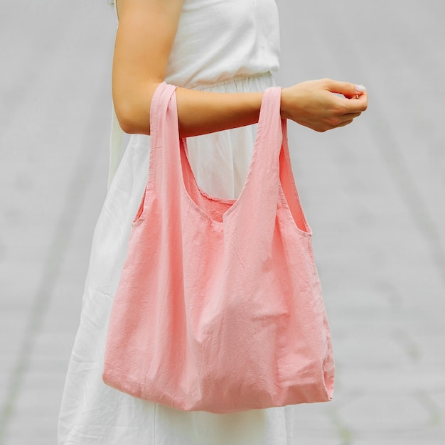 Zdjęcie kobieta trzyma bawełnianą eko torbę. ekologiczna torba wielokrotnego użytku na zakupy. koncepcja zero odpadów. makieta