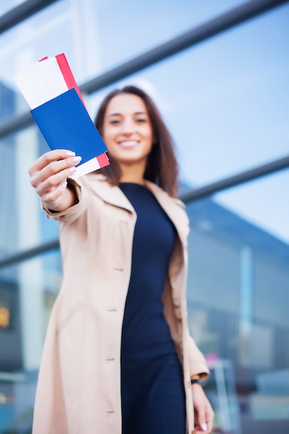 Kobieta trzyma dwa lotniczy bilet w zagranicznym paszporcie blisko lotniska