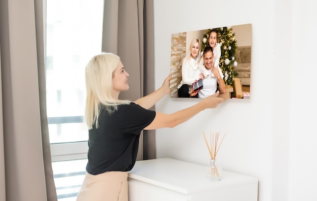 kobieta trzyma fotografię z rozciągnięciem galerii na drewnianej ramie. Wydrukowane zdjęcie na płótnie.