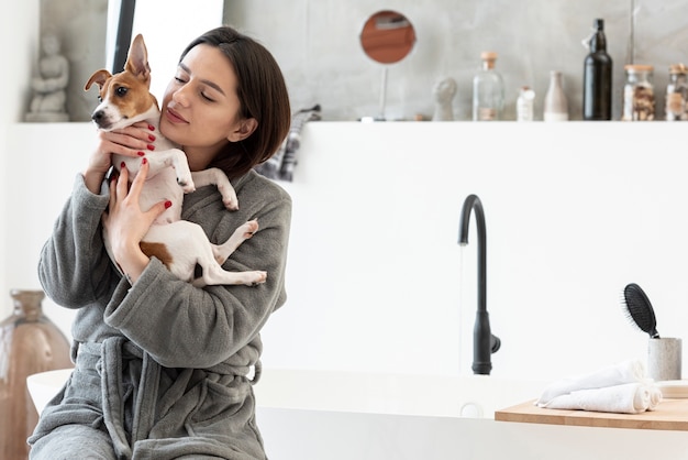 Zdjęcie kobieta trzyma jej psa w szlafroku