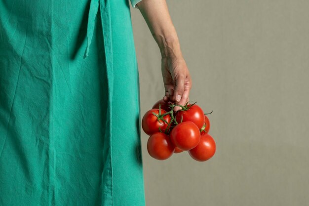 Kobieta trzyma kiść pomidorów winorośli pień fotografia