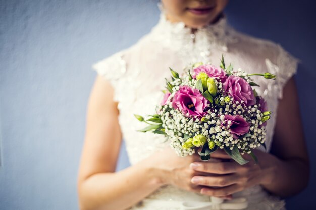 Kobieta trzyma kolorowy bukiet z rękami w dniu ślubu