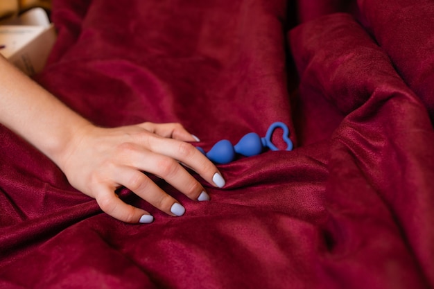 Kobieta trzyma kulki analne w łóżku zbliżenie