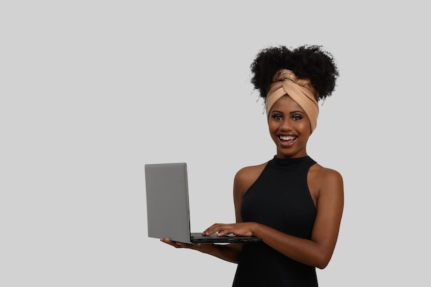 Kobieta trzyma laptopa z szarym tłem