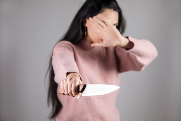 Kobieta trzyma nóż i znak stop