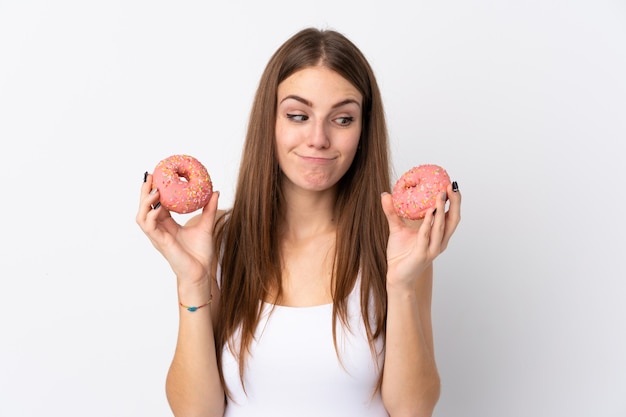 kobieta trzyma pączki nad odosobnioną ścianą