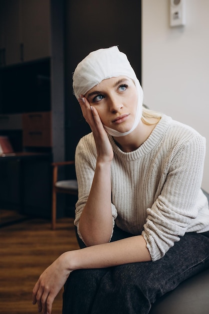 Kobieta trzyma się głowy bandaż na głowie