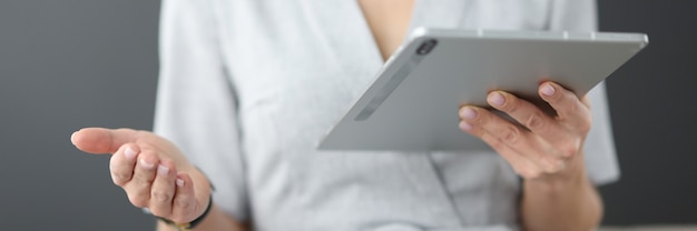 Kobieta trzyma tablet w rękach i macha ręką w koncepcji edukacji biznesowej biura