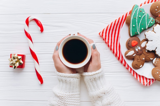 Kobieta trzyma w rękach gorącej kawy, candy cane z ozdób choinkowych.