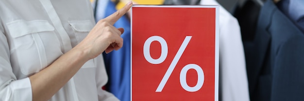 Zdjęcie kobieta trzyma znak z oznaczeniem rabatu w koncepcji obniżenia ceny zbliżenie sklepu